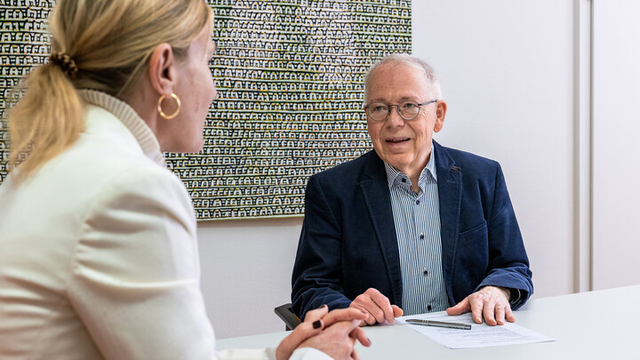 Dr. Gerhard Metzger im Gespräch. Er sitzt an einem Tisch.
