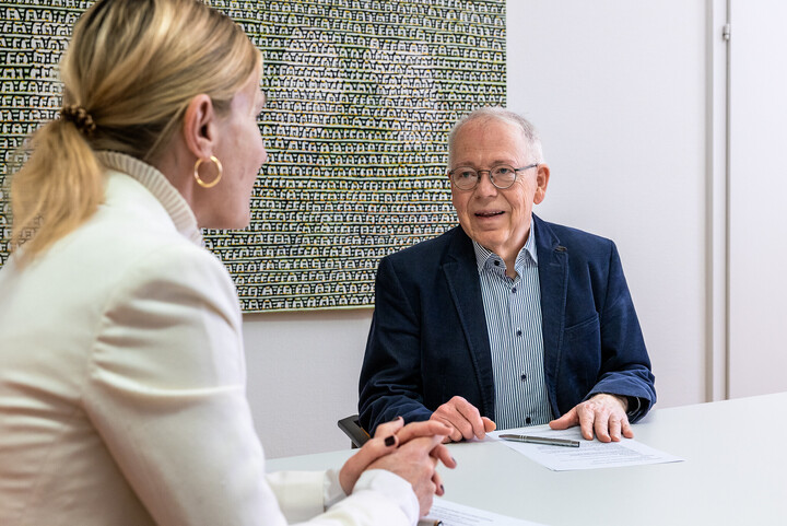 Dr. Gerhard Metzger im Gespräch. Er sitzt an einem Tisch.