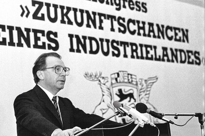 Historisches Foto in schwarz-weiß, das Lothar Spät auf einem Podium zeigt. Im Hintergrund steht: Kongress "Zukunftschancen eines Industrielandes"