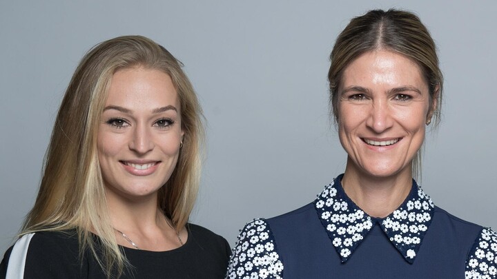 Larissa Schilde und Sarah Seidl lächeln in die Kamera. Larissa Schilde trägt einen schwarzen Pullover und Sarah Seidl ein blaues Oberteil.