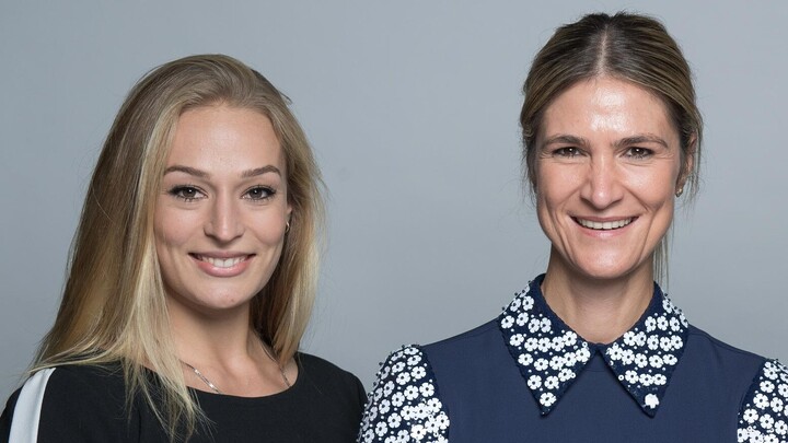 Larissa Schilde und Sarah Seidl lächeln in die Kamera. Larissa Schilde trägt einen schwarzen Pullover und Sarah Seidl ein blaues Oberteil.