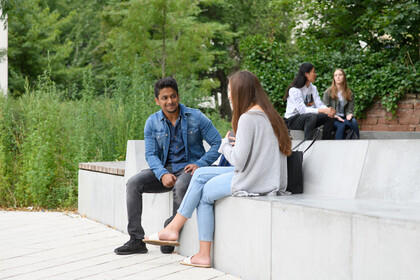 Studierende sitzen im B6 Innenhof.