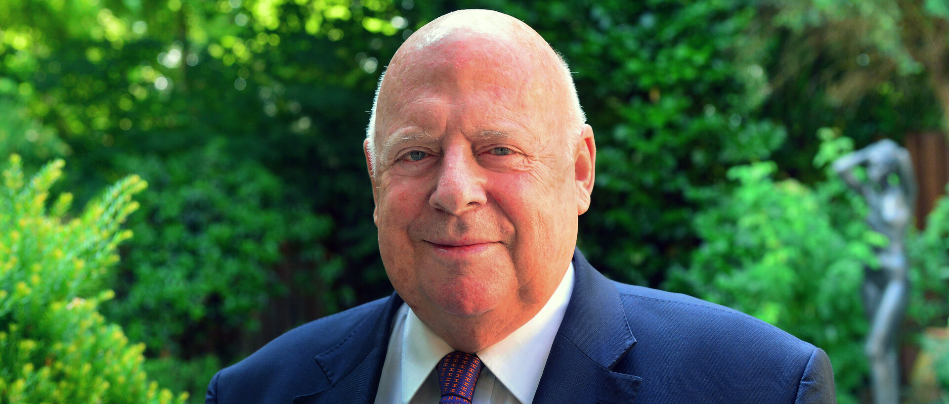 Portraitfoto eines Mannes in Anzug. 