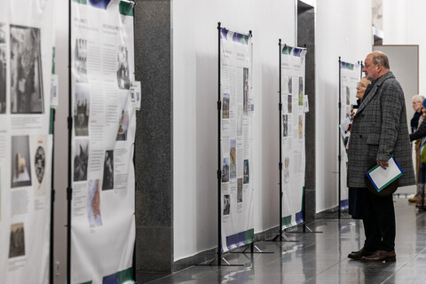 Mehrere Personen lesen Ausstellungstafeln bei einer Vernissage