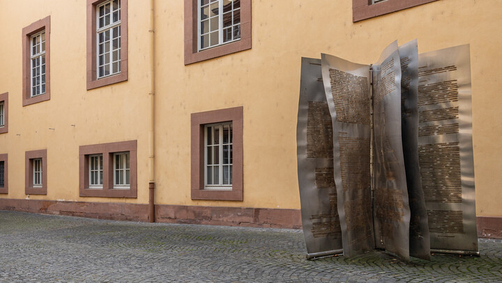 Große Metallskulptur im Wirtschafts­innenhof in Form aufgeschlagener Buchseiten.