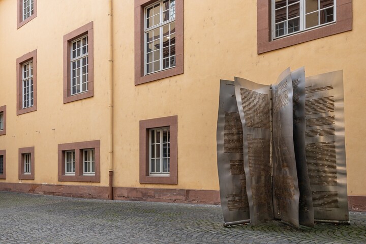 Große Metallskulptur im Wirtschafts­innenhof in Form aufgeschlagener Buchseiten.