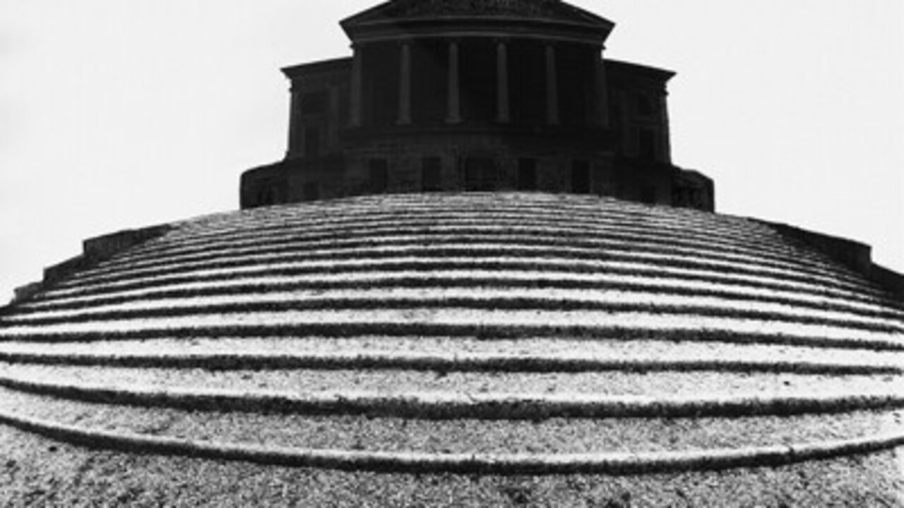 Schwarz-weiß Foto: Stufen, die zu einem antiken Gebäude führen.