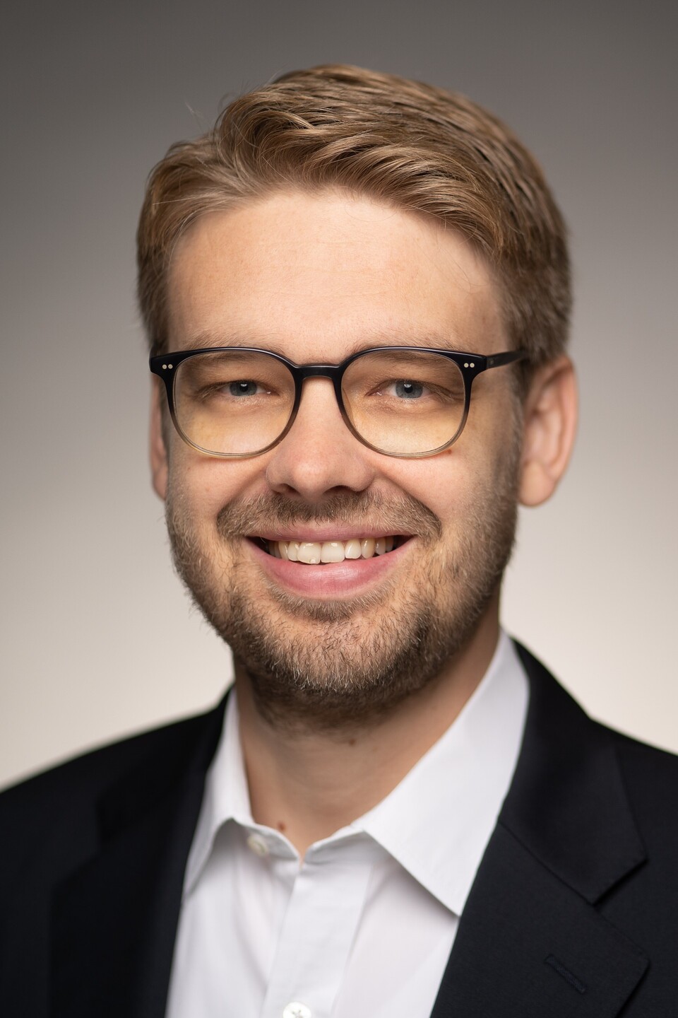 Prof. Dr. Marc Lerchenmüller hat blonde kurze Haare und einen Bart. Er trägt ein dunkles Jacket und ein weißes Hemd.