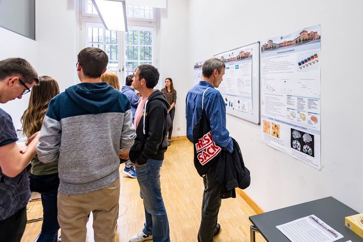 Eine Gruppe von Interessierten schaut sich eine wissenschaftliche Ausstellung an.