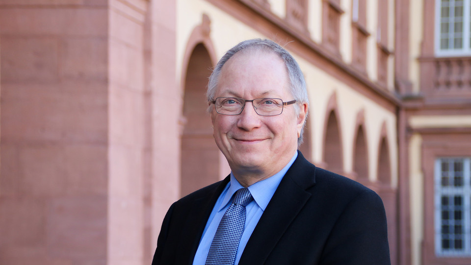 Portrait von Edgar Erfelder. Er trägt einen schwarzen Anzug mit blau-gemusterter Krawatte.