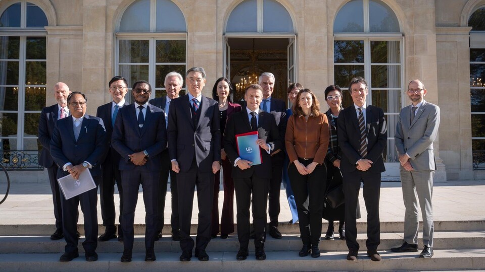 Frankreichs Präsident Macron und die Mitglieder des U7+ Steering Committees stehen vor dem Elysée Palast