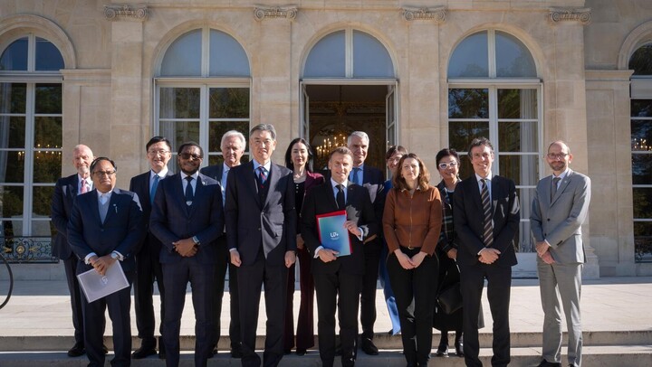 Frankreichs Präsident Macron und die Mitglieder des Leitungsgremiums von U7+ stehen vor dem Elysée Palast