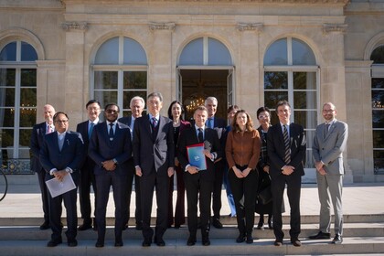 Frankreichs Präsident Macron und die Mitglieder des U7+ Steering Committees stehen vor dem Elysée Palast