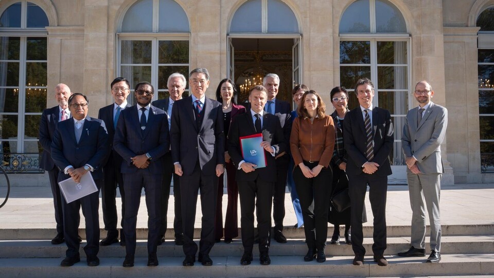Frankreichs Präsident Macron und die Mitglieder des U7+ Steering Committees stehen vor dem Elysée Palast