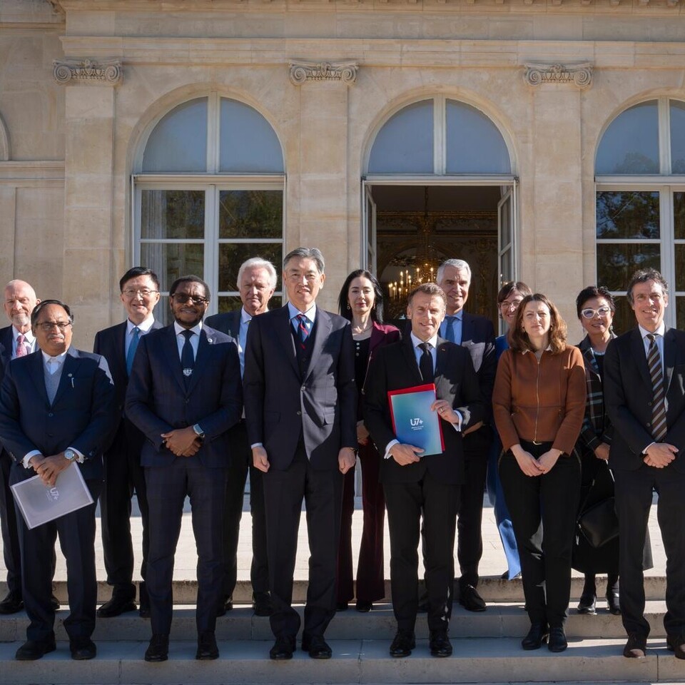 Frankreichs Präsident Macron und die Mitglieder des U7+ Steering Committees stehen vor dem Elysée Palast