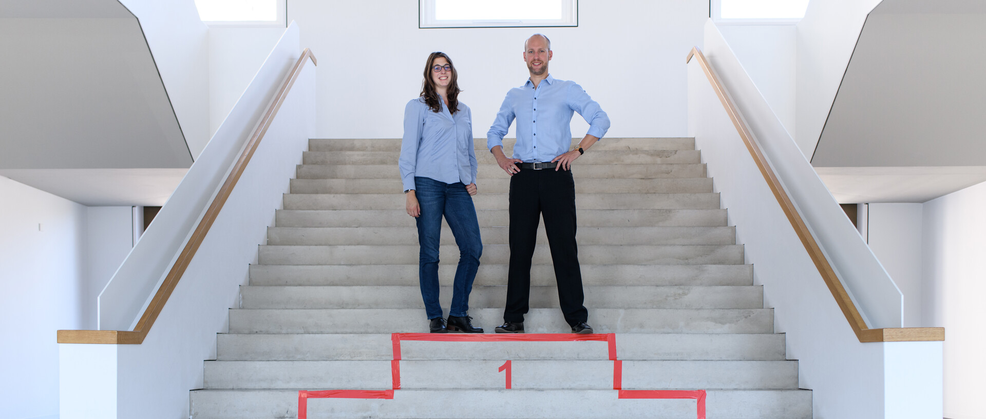 Mann und Frau stehen auf Platz 1 eines imaginären Podests im Bauteil B6 der Universität Mannheim.