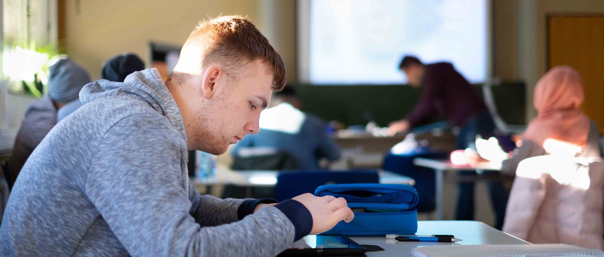 Schüler in Klassenzimmer sitzt am Schreibtisch