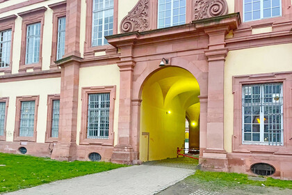 Durchgang des Universitätsgebäudes Ehrenhof-West. Zu sehen ist ein Ausschnitt des Mannheimer Schlosses mit einem Torbogen, durch den man auf die andere Seite des Gebäudes gelangt.