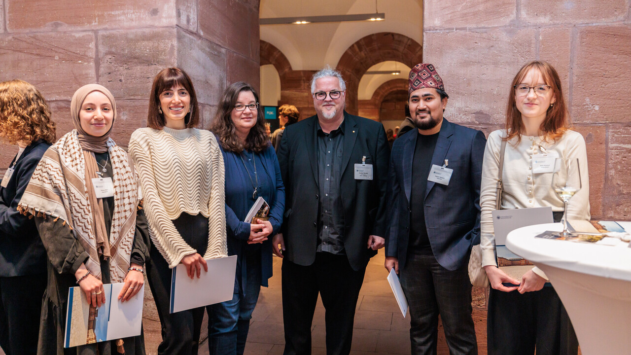 Sechs Personen stehen nebeneinander und posieren für ein Foto.