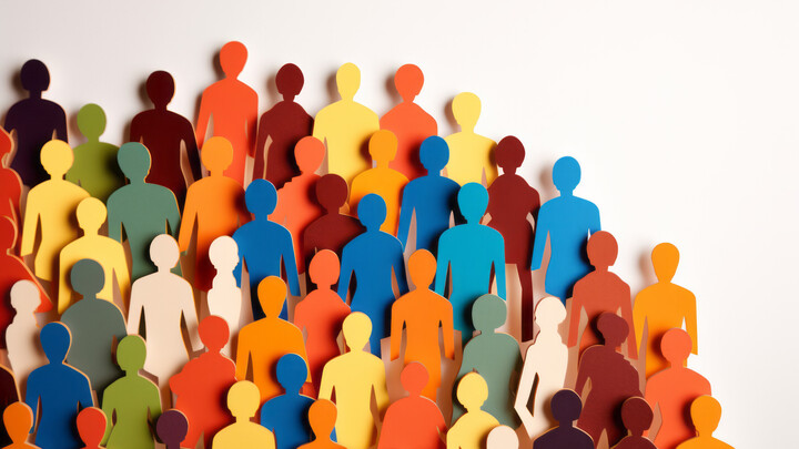 Bunte Papierfiguren vor einem weißen Hintergrund.