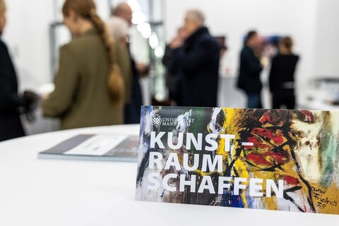 Tischschild mit der Aufschrift "Universität Mannheim Kunstraum schaffen"