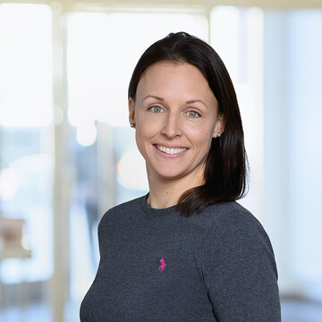 Stefanie Weyres-von Levetzow hat schulterlange braune Haare. Sie trägt ein dunkelgraues Oberteil.