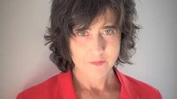 Irena Kogan hat kurze, dunkle Haare und trägt einen roten Blazer. 