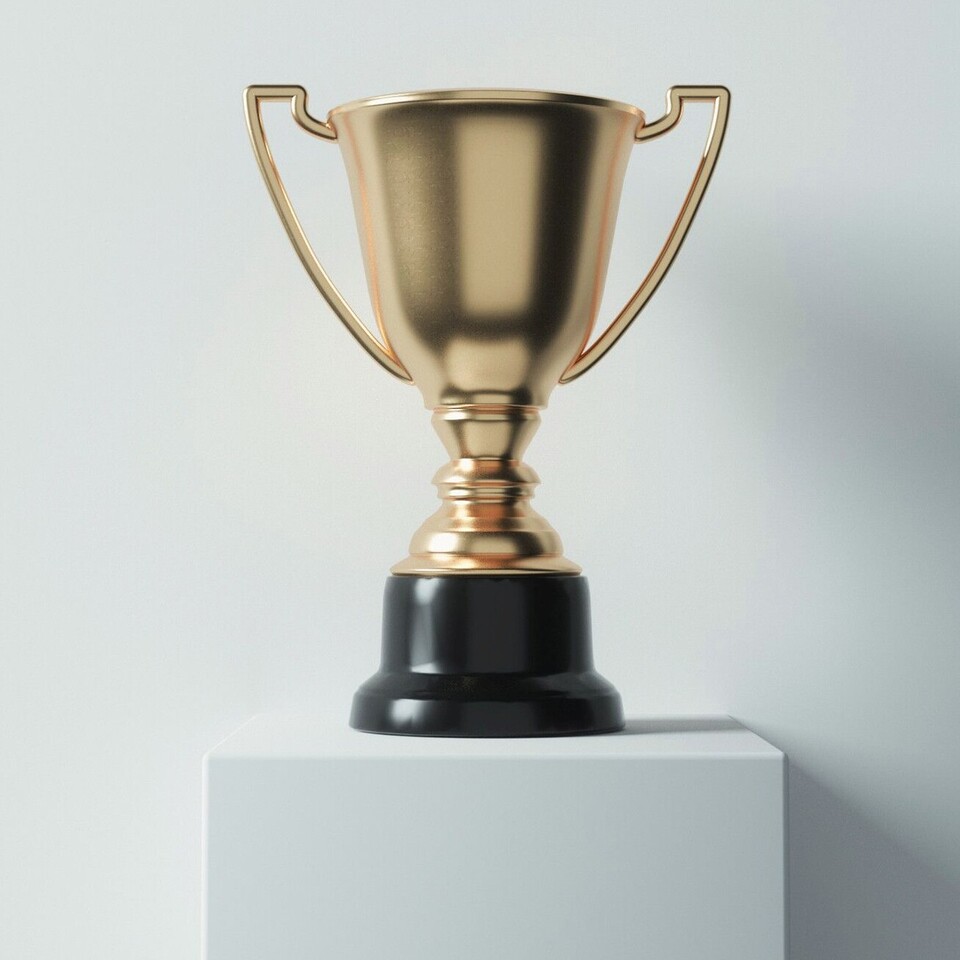 Goldener Pokal auf einem weißen Sockel vor einer weißen Wand.