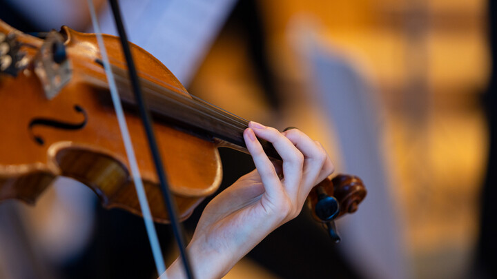 Nahaufnahme einer Geige, die von einer Musikerin gespielt wird.