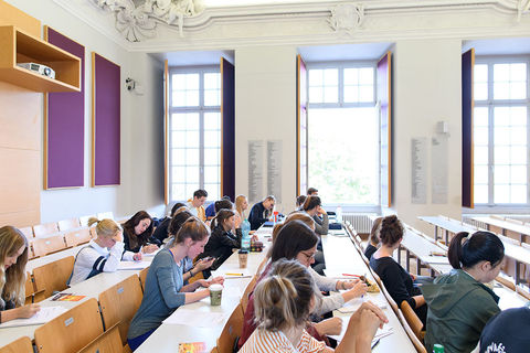 Students sit in a small lecture hall.