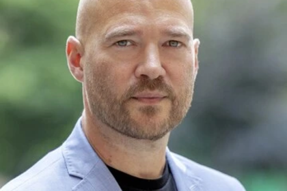 Richard Traunmüller trägt einen hellblauen Anzug. 