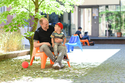 Vater und Sohn sitzen auf dem Gelände der Universität Mannheim