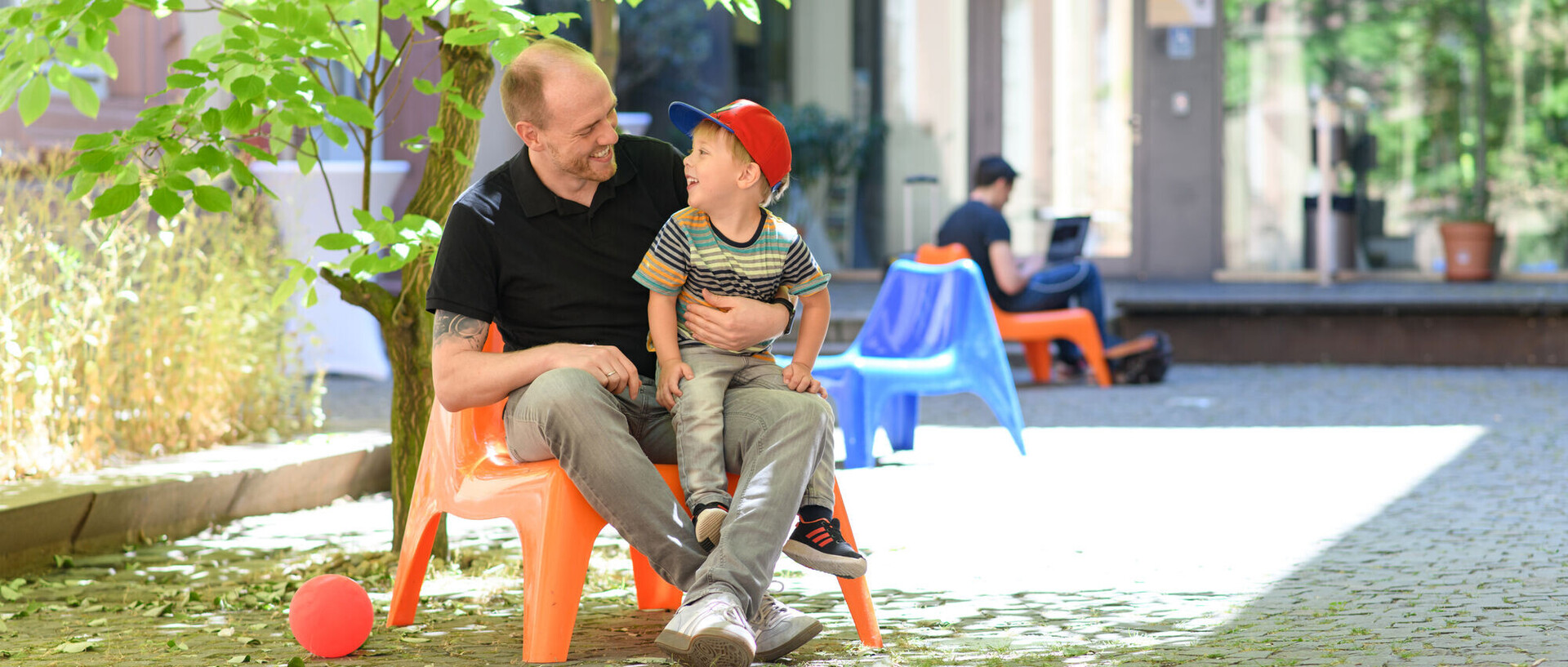 Vater und Sohn sitzen auf dem Gelände der Universität Mannheim