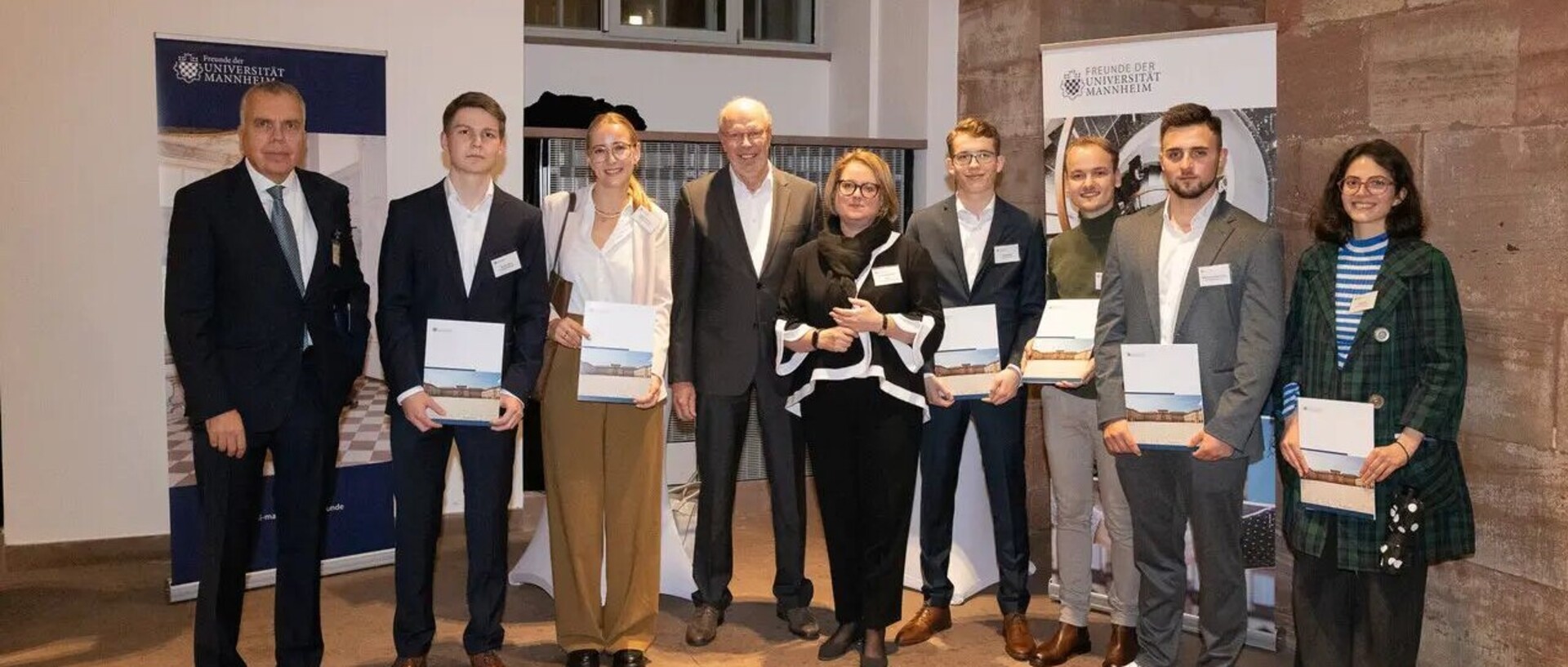 Stipendienfeier in den Katakomben der Uni Mannheim, Studenten posieren mit Urkunden in der Hand