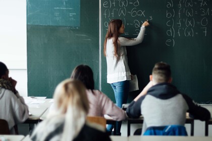 Lehererin vor Klasse an Tafel 