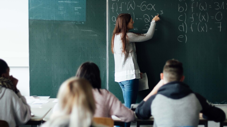 Lehererin vor Klasse an Tafel