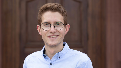 Bjarne Horst. He is wearing a blue shirt and is standing in front of a brown door.