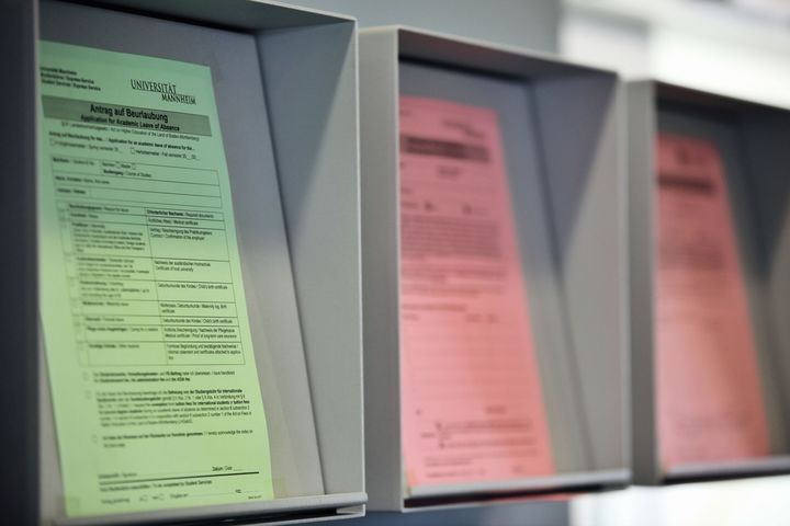 Drei Anträge der Universität Mannheim, von denen zwei auf roten Blatt und einer auf grünem Blatt gedruckt wurde. Auf dem Grünen steht "Antrag auf Beurlaubung".