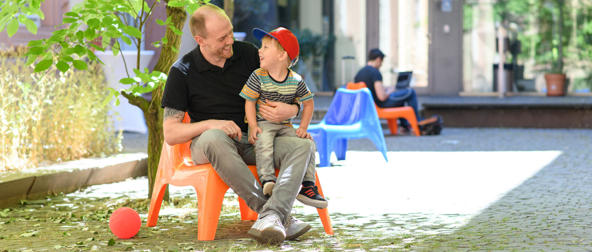 A staff member has his smiling son on his lap.