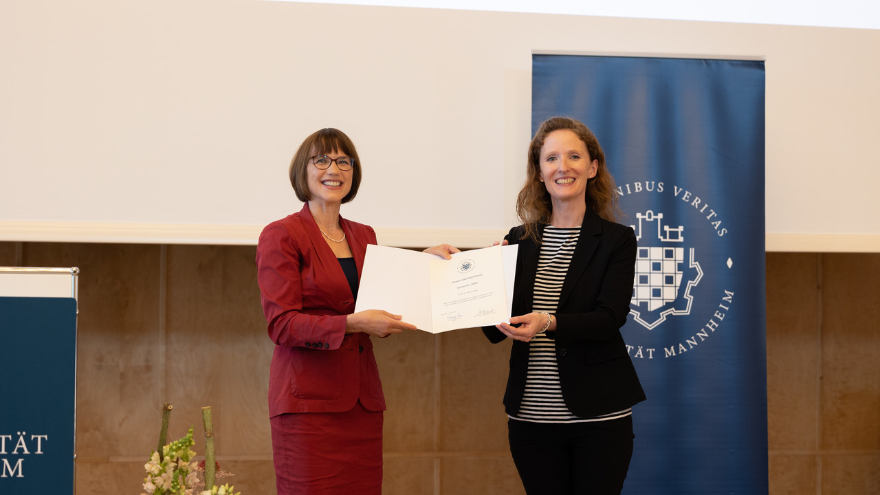 Prof. Dr. Annette Kehnel überreicht Prof. Dr. Karin Hoisl eine Urkunde für den Lehrpreis 2022 der Universität Mannheim