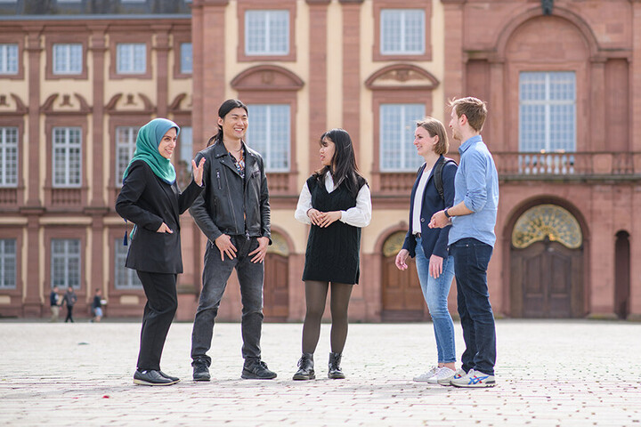 Five Students conversing on the Ehrenhof. 
