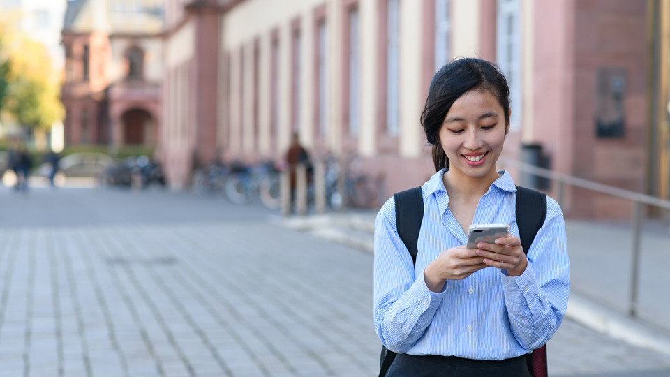 Studentin vor Uni Studentin mit Smartphone