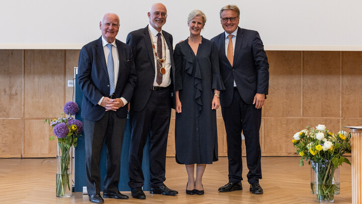 Vier Personen stehen auf einer Bühne: Manfred Fuchs, Thomas Puhl, Susanne Fuchs und Stefan Fuchs. Vorne rechts steht eine Vase mit Blumen.