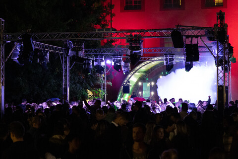 Menschen feiern im Dunkeln auf dem Schneckenhof der Universität Mannheim.