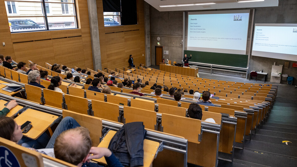 Blick in den großen Hörsaal. Florian Keusch begrüßt die Teilnehmenden