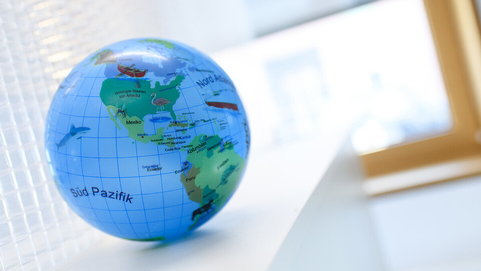 Eine Weltkugel liegt auf einem weißen Tisch