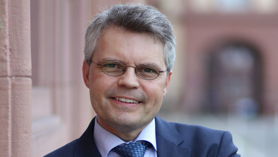 Ralf Müller-Terpitz trägt einen dunkelblauen Anzug mit Krawatte.