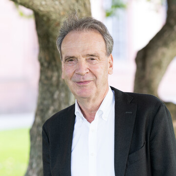  Prof. Stefan Reichelstein. Er lächelt und trägt einen schwarzen Anzug.