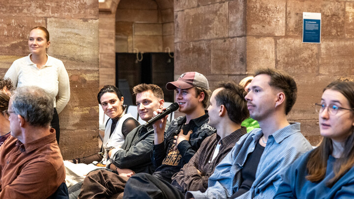 Zuschauer stellt eine Frage mit dem Mikrofon in der Hand während der Hauptveranastaltung der Diversity Week.