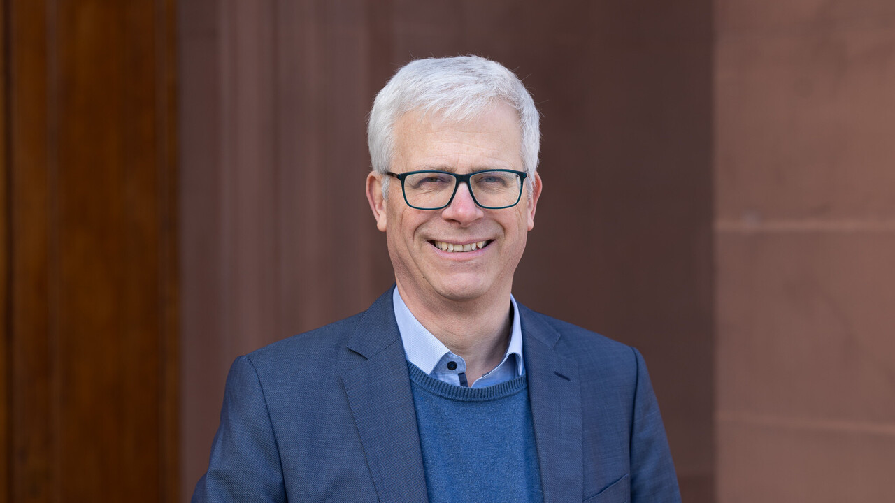 Prof. Dr. Eckhard Janeba hat graue Haare und eine Brille. Er trägt ein blaues Jacket.